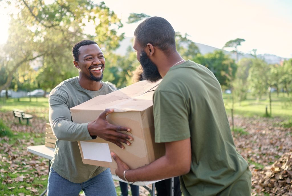 Black man, charity and holding box in park of donation, community service or social responsibility.